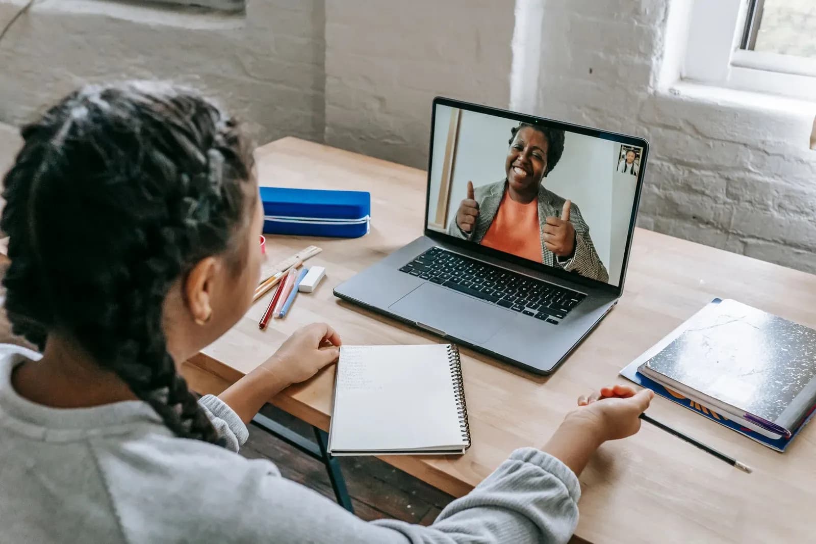 Teen student in a 1-to-1 online tutoring session with notebook open