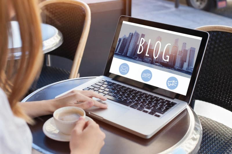 image of a sophisticated woman reading this blog on her laptop in a coffee shop